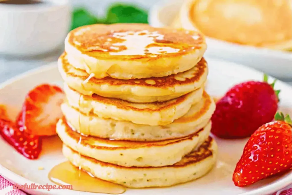 fluffy golden mini pancakes stacked on a plate